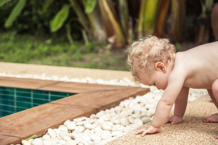 Baby learning walking making efforts to get upの写真素材