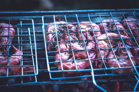 Delicious barbecue prawns cooking on grill with hot red charcoalの写真素材
