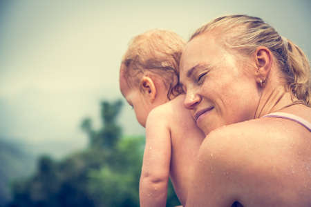 Mother sincerely hugging his child during vacation with copy space. Conceptual picture symbolizing baby care and loveの写真素材