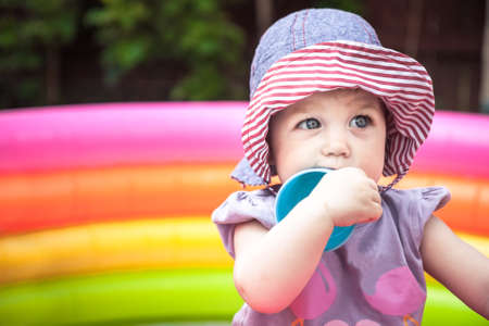 Beautiful baby girl playing in playpen with toys in the parkの写真素材