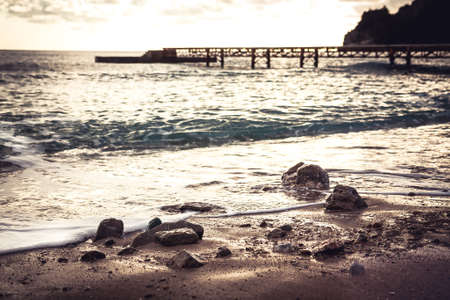 Sunset beach toned landscape with stones on coastlineの写真素材