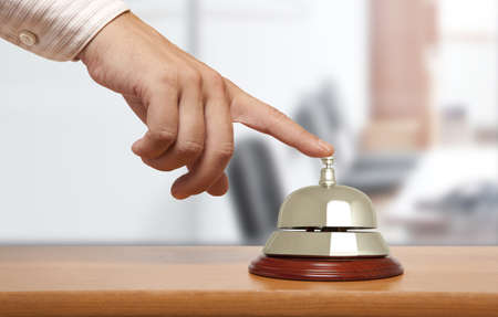 Hand of a man using a hotel bell の写真素材