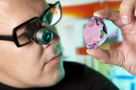 Jeweller appraising quality of diamond の写真素材
