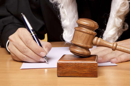 Referee hammer and a man in judicial robesの写真素材