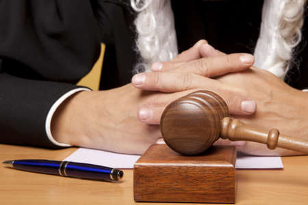 Referee hammer and a man in judicial robesの写真素材