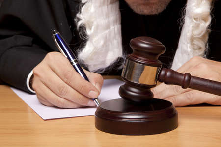 Referee hammer and a man in judicial robesの写真素材