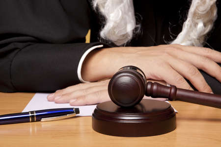 Referee hammer and a man in judicial robesの写真素材