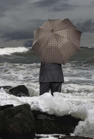Economic crisis. Businessman with umbrellaの写真素材