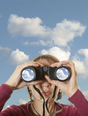 Attractive woman with binoculars in the skyの写真素材