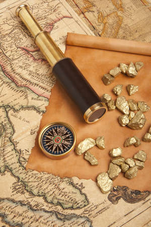 Gold nuggets and vintage brass telescope on antique map