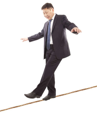 Asian businessman rope-walker. Isolated on white background の写真素材