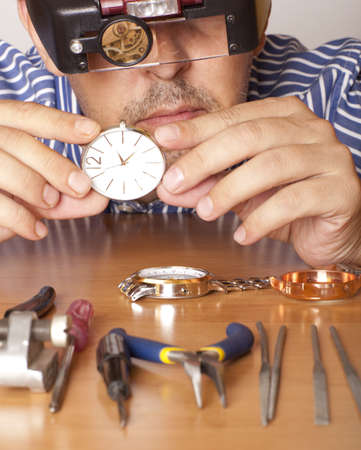 Watch repair craftsman repairing watch. Focus on watchの写真素材