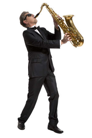 Middle-aged manplaying on saxophone isolated on backgroundの写真素材