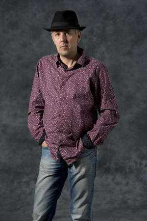 Middle aged man portrait with hat on black background