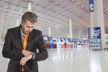 Flight delay. Businessman looking at his watchの写真素材