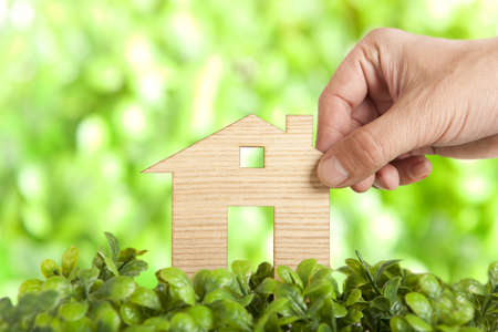 Wooden model house in green field の写真素材