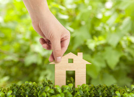 Wooden model house in green fieldの写真素材