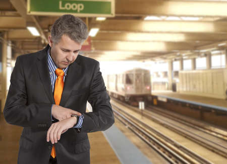 Train delay. Businessman looking at his watchの写真素材