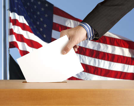 Hand with ballot and box on Flag of USA