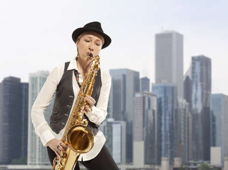 Saxophonist. Woman playing on saxophone against the background of skyscraper