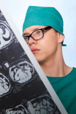 Male doctor examines X-ray picture of a human brain の写真素材