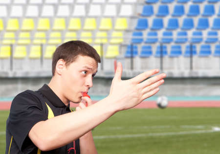 Male referee against the football stadium
