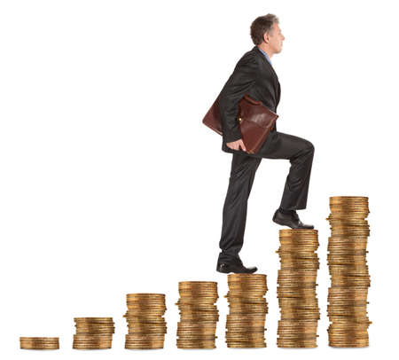 Businessman goes up the gold coins on a white backgroundの写真素材
