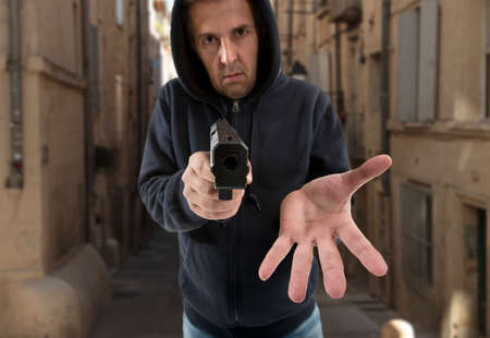 one man gangster is aiming a gun to youの写真素材