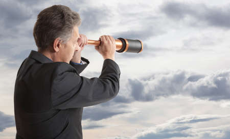 Business concept.  Business man looks through a telescopeの写真素材