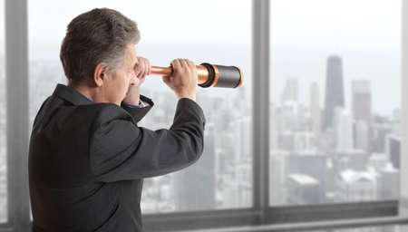Business concept.  Business man looks through a telescopeの写真素材