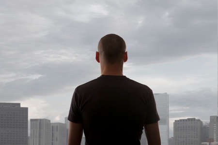 Men standing on the rooftop of a skyscraper over a cityscapeの写真素材