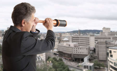 Business concept.  Business man looks through a telescope