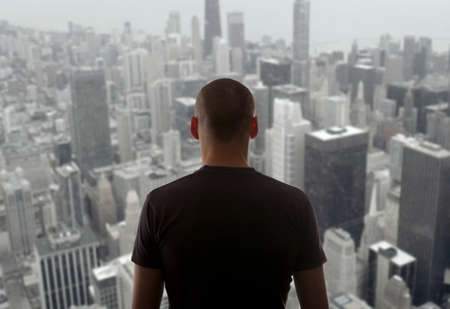 Men standing on the rooftop of a skyscraper over a cityscapeの写真素材