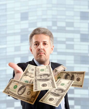 Handsome adult businessman throwing dollarの写真素材