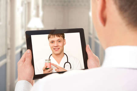 Man having video chat with doctor on laptop at home