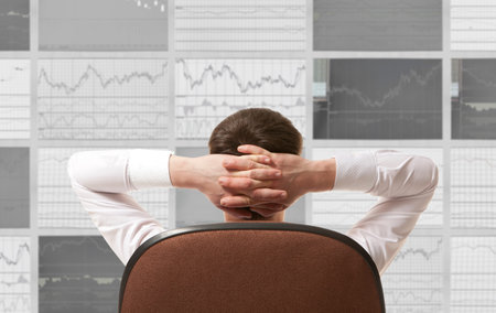 Stock trader looking at monitors