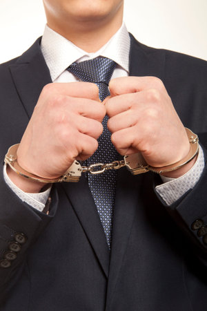 Worried caucasian middle aged businessman in handcuffsの写真素材