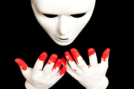 White theatrical mask and blood on their handsの写真素材