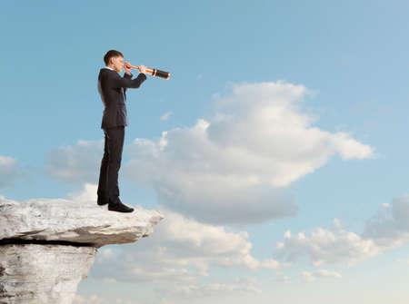 Businessman looks through a telescope. Concept for businessの写真素材
