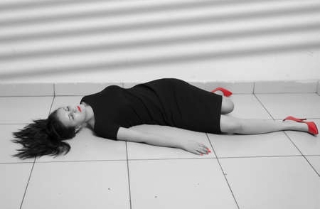 Crime scene imitation. Lifeless business woman lying on the floorの写真素材