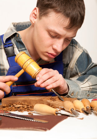 Young craftsman in uniform working at carpentry