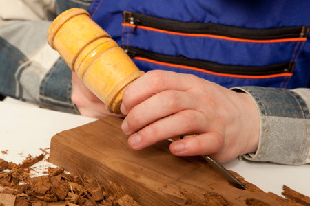 Young craftsman in uniform working at carpentry