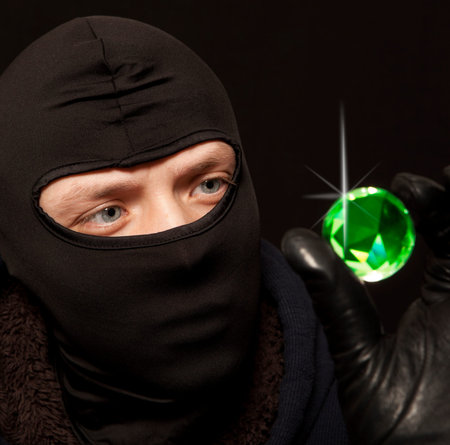 Thief. Man in black mask with a big emerald. Focus on thief