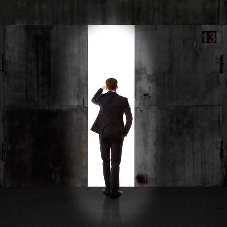 Infinity. Rear view of a businessman standing in front of the exit lightの写真素材