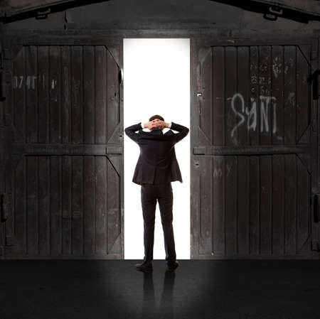 Infinity. Rear view of a businessman standing in front of the exit lightの写真素材