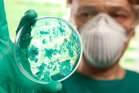 Scientist holding a petri dish with virus cells