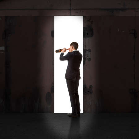 Infinity. Rear view of a businessman standing in front of the exit lightの写真素材