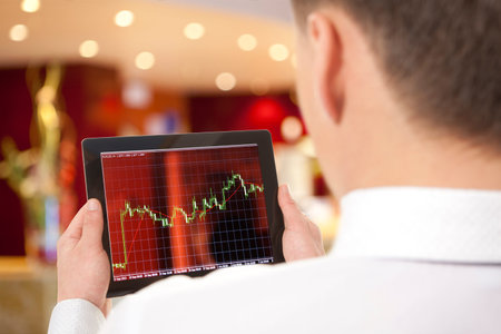 Businessman checking the stock market on digital tablet in office