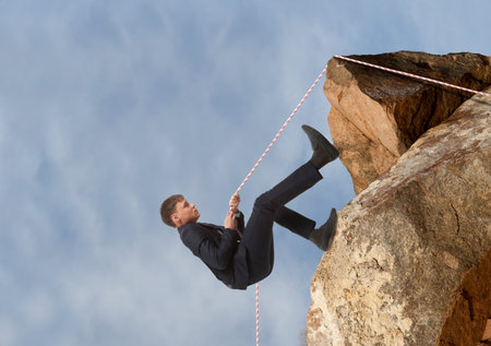 Businessman scaling a rock. Business concept
