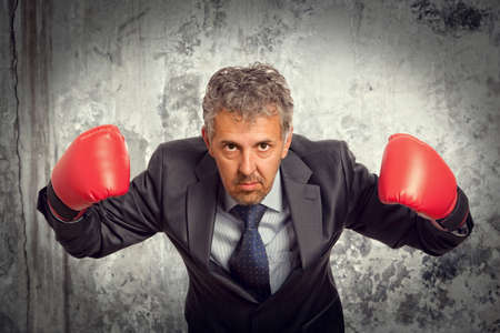 Businessman in red boxing gloves on backgroundの写真素材